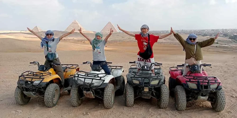 Quad bike ride across the sandy desert near the Giza Pyramids under a clear blue sky