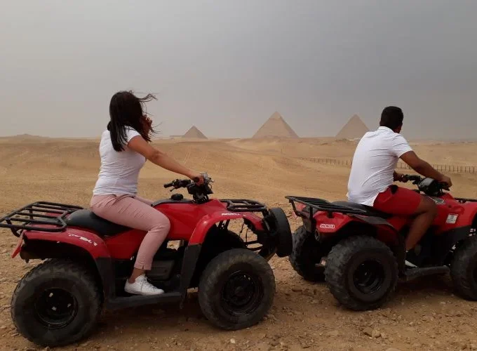 Two people riding a quad bike near the Pyramids of Giza