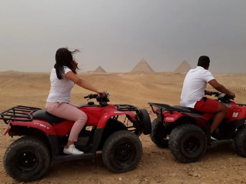 Two people riding a quad bike near the Pyramids of Giza