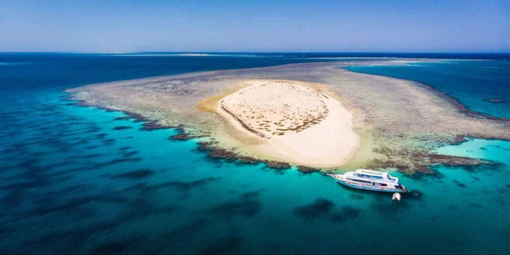 Aerial view of Hamata Island with clear turquoise waters and white sandy beaches.