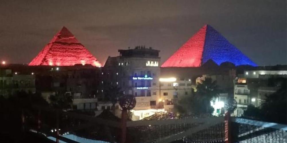 Vista noturna das Pirâmides de Gizé durante o espetáculo de som e luz, com projeções e efeitos visuais.