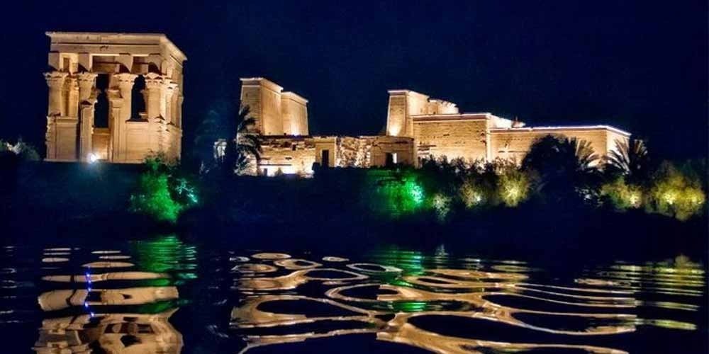 Philae Temple illuminated during the Sound and Light Show with reflections on the water