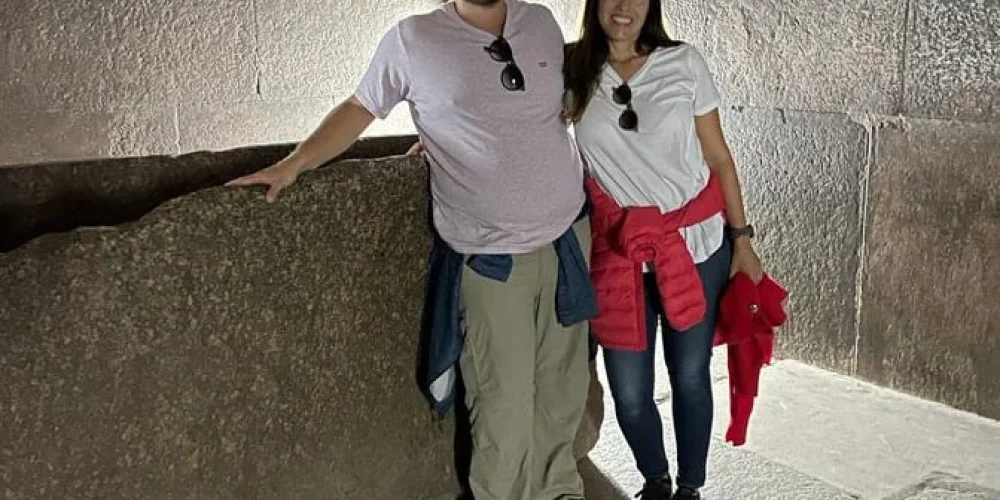 Una pareja dentro de la Gran Pirámide de Guiza explorando sus pasillos internos.