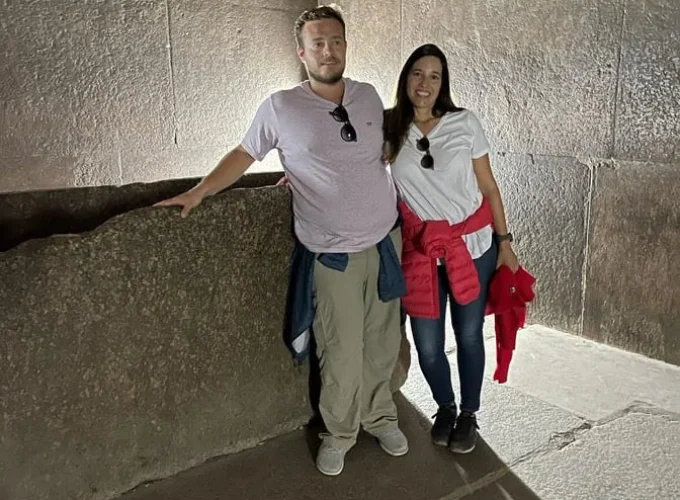 Una pareja dentro de la Gran Pirámide de Guiza explorando sus pasillos internos.