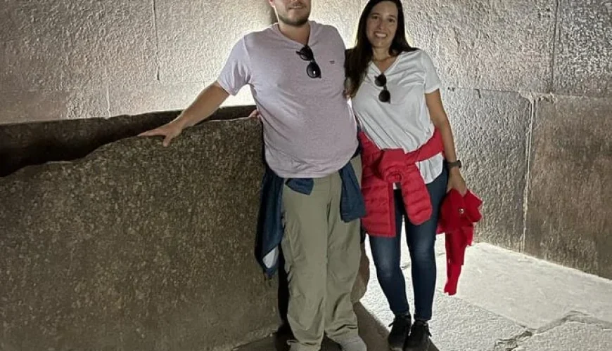 Una pareja dentro de la Gran Pirámide de Guiza explorando sus pasillos internos.