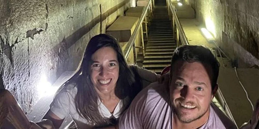 Una pareja dentro de la Gran Pirámide de Giza, explorando su interior.