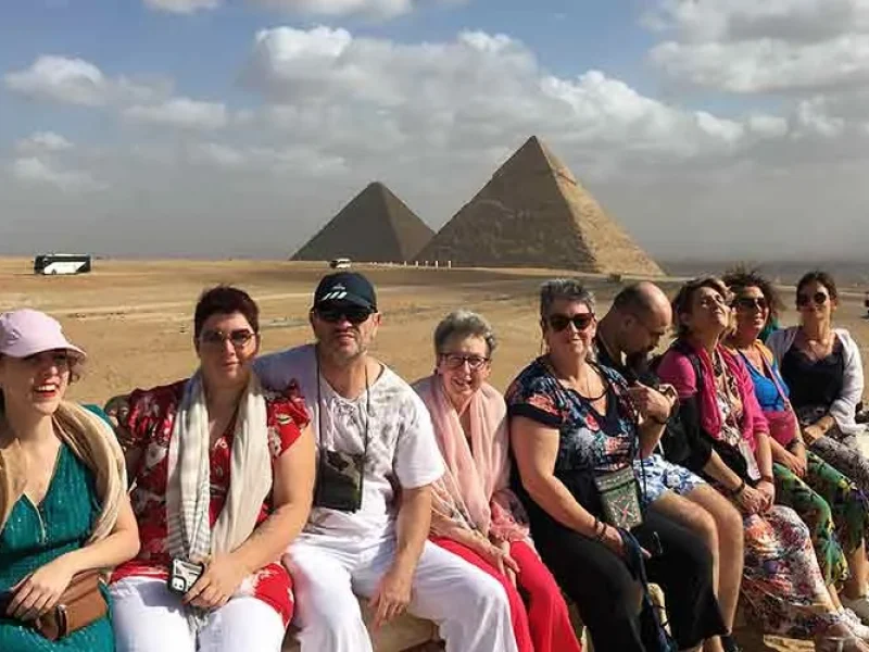 Un grupo de turistas posando frente a las Pirámides de Guiza