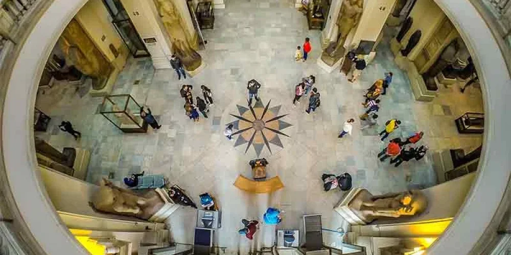 Sala del Museo Egipcio en El Cairo, repleta de tesoros del Antiguo Egipto, incluyendo estatuas y objetos funerarios.