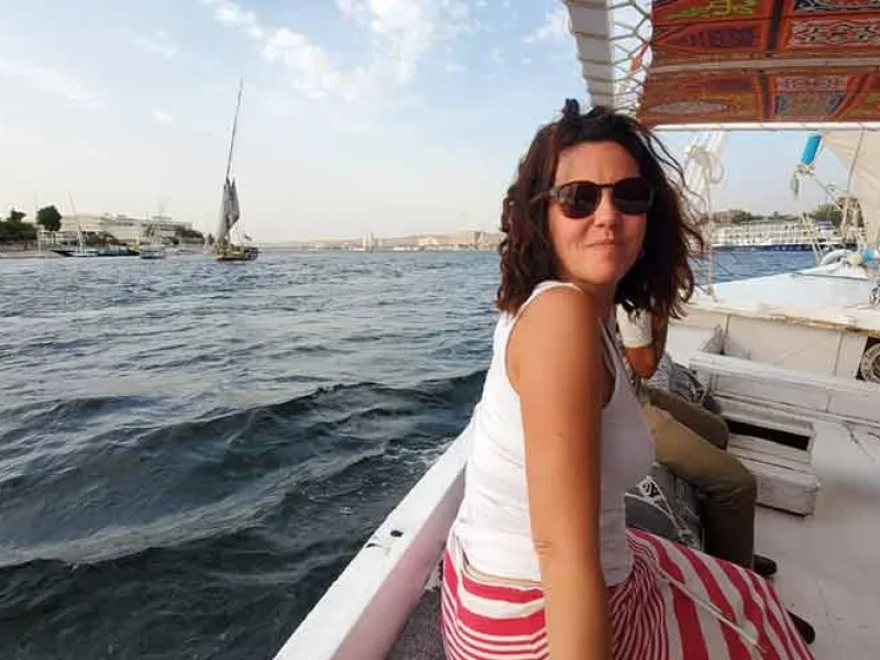 A tourist enjoying a felucca ride on the Nile River surrounded by fresh air and water