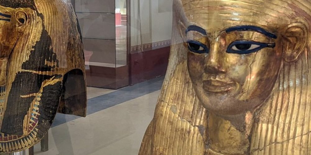 Masques funéraires en or exposés dans une vitrine de musée durant une Visite au Caire depuis Marsa Alam.