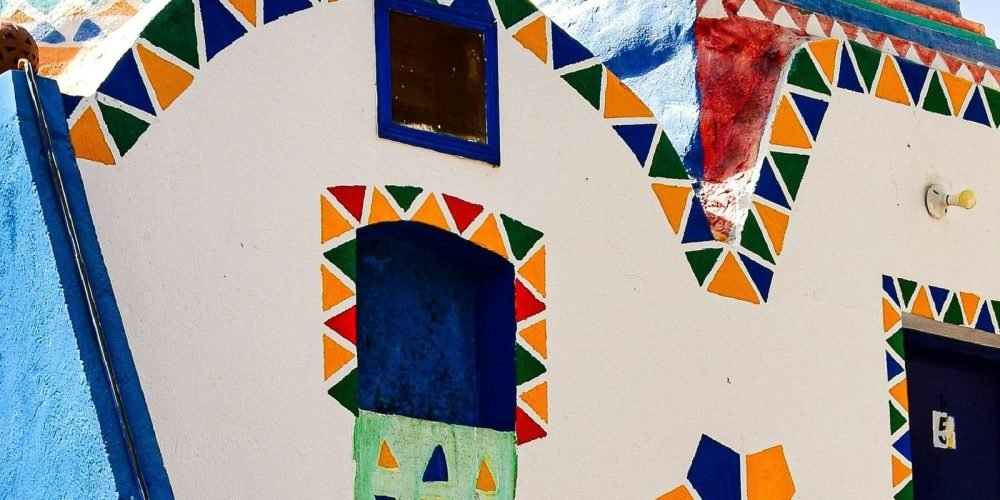 Façade d'une maison nubienne traditionnelle aux motifs géométriques colorés et dôme peint, vue lors d'une Visite inoubliable a Souk du Assouan et village nubien