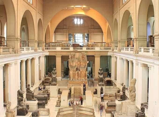 Interior do Museu Egípcio do Cairo com estátuas e artefatos antigos em exposição.