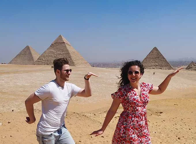 A couple enjoying their time in front of the Pyramids in a delightful scene