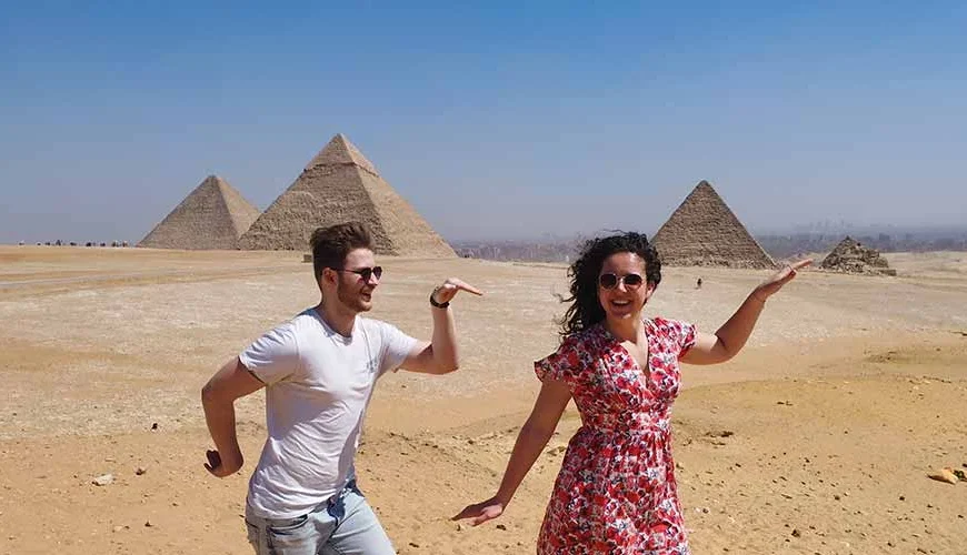 A couple enjoying their time in front of the Pyramids in a delightful scene