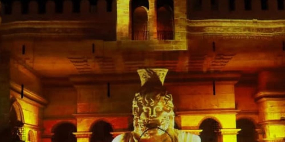 Projection lumineuse d'un buste pharaonique sur les murs dorés de la forteresse durant le spectacle son et lumière de la citadelle de Qaitbay